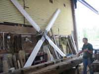 Ernie works on repairing a beam... his new project is in the background...a giant windmill.
